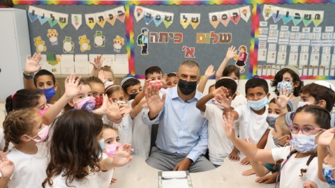 ראש העיר רפי סער עם ילדי כתה א בבית הספר בר-אילן מנופפים לשלום בפתיחת שנת הלימודים