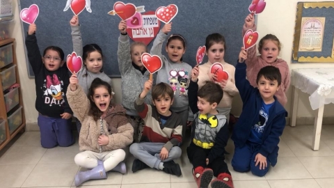 ילדי גן האהבה מניפים כרטיסי ברכה בצורת לבבות