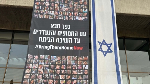 באנר בכפר סבא הקורא להשבת החטופים והנעדרים הביתה