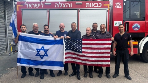 משלחת לוחמי האש ממיאמי בתחנת הכיבוי וההצלה בכפר סבא מניפים יחד דגלי ישראל וארצות הברית