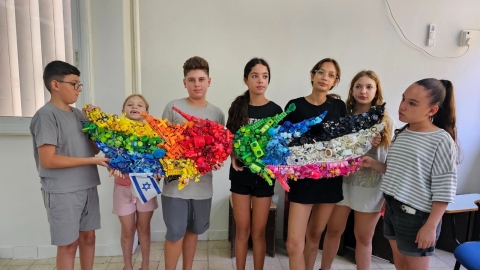 תלמידי כפר סבא עם מיצב של כנפיים ענקיות שהכינו בהפנינג צבע בעיר